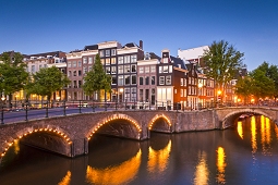 Charming Amsterdam canal bridge lighted at the corner of Keiszergracht, one of the three original canals created within the ring of canals